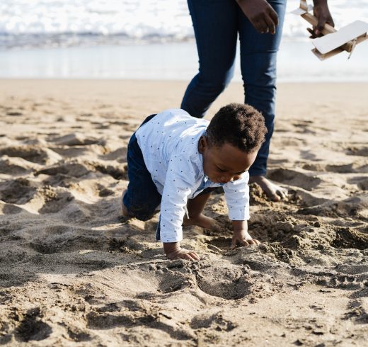 African baby having fun with his parents at the beach - Focus on kid face